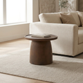 Single brown Teddy Stone Table with a book beside a cream sofa.